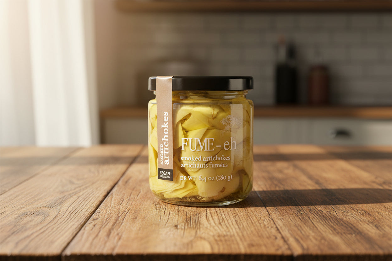 Jar of yellow smoked artichokes with black lid, labeled "FUME-eh," vegan, 6.4 oz.
